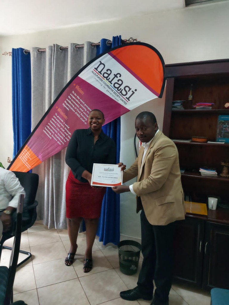 Nafasi Multipurpose Cooperative Society member certificate handover with official vision and mission banner